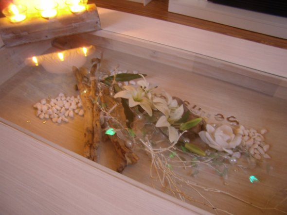 In den Tisch mit Schublade habe ich Treinholz gesammelte Steine Blüten und eine Lichterkette dekoriert