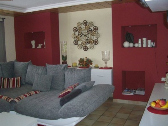 Hinter der Couch verbirgt sich eine Hängekommode. 
Seitlich die roten Säulen sind aus glatten Gipskarton aufgebaut. 
Zwei Fächer mit ind